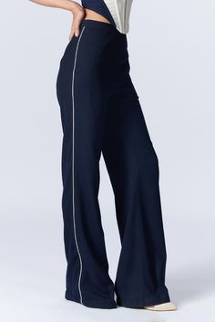 Navy wide legged trousers with side contrast piping details, side pockets and placement 'S&N' logo thread patch embroidery on waistband.
Components: 1
Pattern: Embroidered
Type Of Work: Thread Patch Work
Fabric: Poly Blend, Viscose, Lycra
Color: Blue
Other Details: 
Tailored trousers
Closure : Back concealed zip
Note: The jacket and inner corset worn by the model is not for sale
Occasion: Work,Party - Aza Fashions Wide Leg Bottoms With Contrast Trim For Work, Workwear Straight Leg Bottoms With Contrast Trim, Straight Leg Workwear Bottoms With Contrast Trim, Straight Leg Bottoms With Contrast Trim For Work, Fitted Wide-leg Pants With Contrast Stitching, Chic Workwear Bottoms With Contrast Stitching, Workwear Bottoms With Contrast Trim, Wide Leg Pants With Elastic Side Panels For Work, Straight Pants With Contrast Stitching For Work