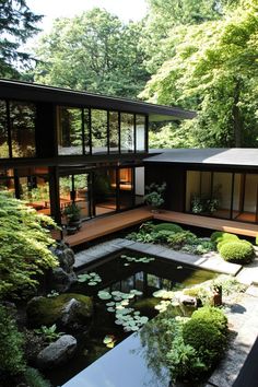 a large pond in front of a modern house surrounded by trees and water lilies