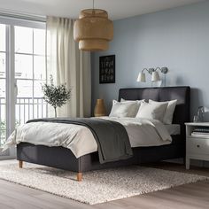 a bedroom with blue walls and white bedding