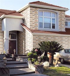 a car parked in front of a house with stone steps leading up to the door