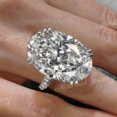 a close up of a person's hand with a diamond ring on their finger