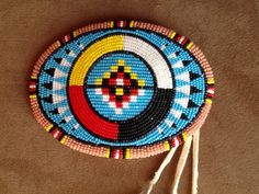 a colorful beaded ornament with tassels hanging from it's side