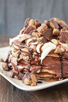 a stack of chocolate and peanut butter waffles on a white plate with drizzle