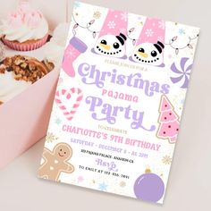 a pink box filled with cupcakes next to a christmas party card on top of a table