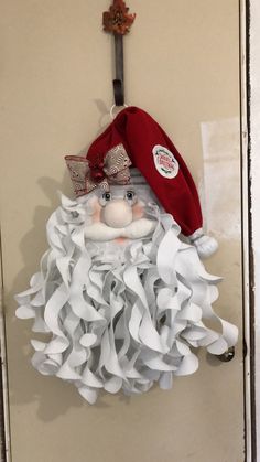 a door hanger with a red hat and white ruffle skirt on it's head