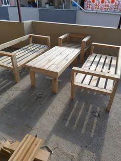 four wooden tables and chairs sitting on top of a cement floor next to each other