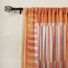 an orange and white striped curtain hanging on a wall