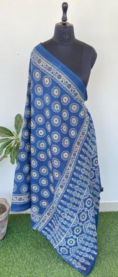 a blue and white sari with an intricate design on the border, sitting next to a