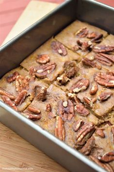 a pan filled with pecan bread on top of a wooden table