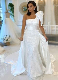 a woman in a white dress is standing on the floor wearing a tiara and gown