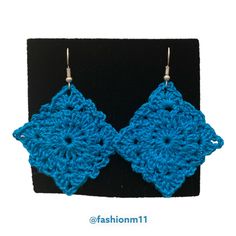 a pair of blue crocheted earrings on a black display stand with the words fashion 11 written below it