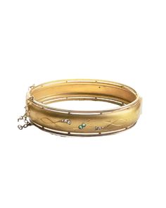 Enhance any outfit with this elegant Victorian bangle bracelet. Adorned with an intricate etched pattern and sparkling green and clear rhinestones, this is a luxurious addition to your wrist stack. Wear it on its own or stack it with your favorites for a stylish look! * gold filled hinged bangle bracelet * 6 1/4" circumference / 2.36" wide * green and clear paste rhinestones  * hinged opening with safety chain * era: Victorian Luxury Gold Etched Bracelet, Vintage Diamond Bangle Bracelet With Accents, Vintage Diamond Bangle With Accents, Vintage Diamond Bangle Jewelry, Jeweled Yellow Gold Bangle Bracelet, Vintage Green Bangle For Wedding, Antique Jeweled Bangle Jewelry, Antique Jeweled Bangle, Vintage Diamond Accented Bangle Bracelets