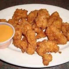 chicken nuggets with dipping sauce on a white plate