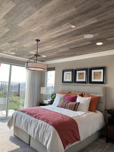 a bedroom with a large bed and two pictures on the wall above it's headboard