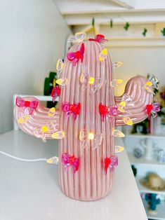 a pink glass cactus sitting on top of a table