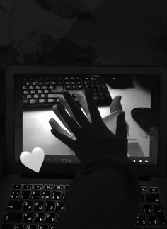 a person using a laptop computer with a heart on the screen