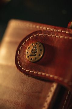 a brown leather wallet with a gold emblem on it