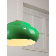 a green light hanging from a ceiling in front of a white door with a window