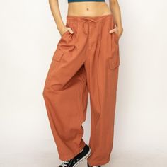 The Drawstring Cargo Wide Leg Pants Are A Trendy And Functional Addition To Your Wardrobe. The Drawstring Waist Allows For A Customizable And Comfortable Fit, While The Cargo Pockets Add A Touch Of Utility And Style. The Wide-Leg Silhouette Adds A Relaxed And Effortlessly Chic Vibe, Making These Pants A Versatile Option For Both Casual And Dressed-Up Looks. Features: Basic Style Sheer: Opaque Material Composition: 100% Cotton Care Instructions: Machine Wash Cold. Tumble Dry Low. Imported Product Relaxed High Waist Cotton Pants, High Waist Relaxed Cotton Pants, Utility Style Drawstring Pants For Loungewear, Utility Drawstring Pants For Loungewear, Relaxed Baggy Drawstring Bottoms, Relaxed Baggy Bottoms With Drawstring, Relaxed Baggy Drawstring Pants, Relaxed Baggy Pants With Drawstring, Cotton Utility Bottoms For Loungewear