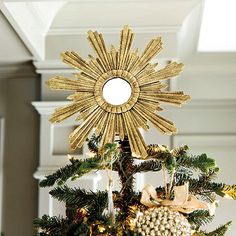 a gold star decoration on top of a christmas tree