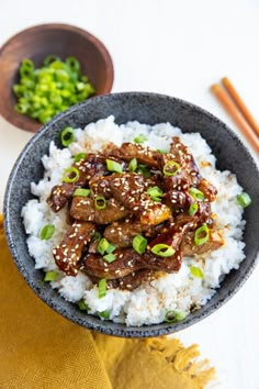 a bowl filled with rice and meat on top of a table