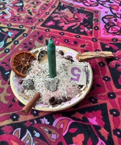 a small plate filled with rice and spices on top of a colorful carpeted floor