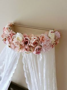 pink and white flowers are hanging on the curtain