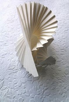 an origami sculpture sitting on top of a white tablecloth covered flooring