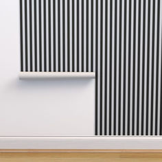 a white and black striped wall next to a wooden floor