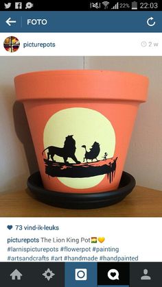 a flower pot with the silhouettes of two lions on it