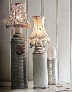 two tin cans are sitting on a shelf with a lamp and an old canister