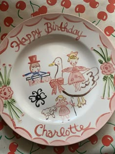 a happy birthday plate on a table with cherries