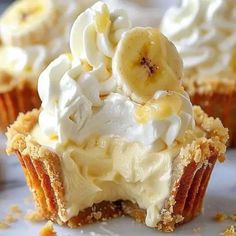 some cupcakes with banana slices and whipped cream on top