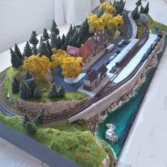 a model train track with houses and trees on it