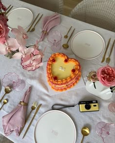 a table topped with plates and cake next to utensils