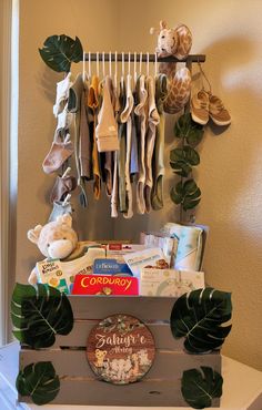 a wooden box filled with baby items on top of a white table next to a green leafy plant