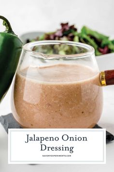 jalapeno onion dressing in a glass jar next to a bowl of salad