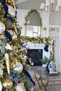 a decorated christmas tree in a living room with blue and gold ornaments on the branches