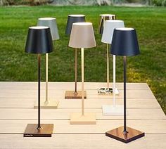 three lamps are sitting on a table outside