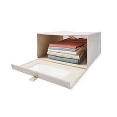 an open storage box with folded sheets and linens in it on a white background