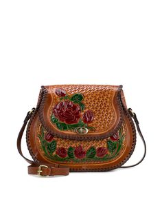 a brown purse with flowers painted on the front and side, sitting on a white surface