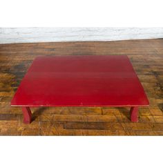 a red table sitting on top of a wooden floor