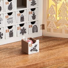 an open box sitting on top of a wooden table next to a wall with christmas decorations