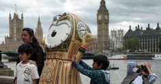 people taking pictures of a clock tower in the middle of london with big ben in the background