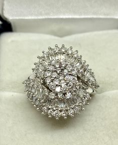 This is a new ring yet vintage from an out of biz fine jewelry store. Size 7 approx 120 diamonds equaling to two carats total diamond weight. This large cluster weigh 5.3 gms, made of 10 kt white gold , stones are round and baguette shaped, very good quality diamonds set in prong settings. A classic timeless ring which is remarkable as a dinner or cocktail ring, an engagement ring or an April birthstone. Sparkly and exquisite! Dazzling White Gold Diamond Ring With Baguette Diamonds, Luxury Cluster Cut Diamond Ring, Luxury Cluster Diamond Ring, Luxury Cluster-cut Diamond Ring, Platinum Cluster Diamond Ring With Baguette Diamonds, Dazzling Cluster Baguette Diamond Rings, Dazzling Baguette Diamond Cluster Rings, Dazzling Cluster Rings With Baguette Diamonds, Diamond White Diamond Ring With Baguette Diamonds