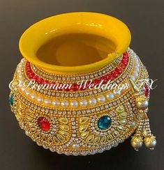 a yellow vase with some beads on it