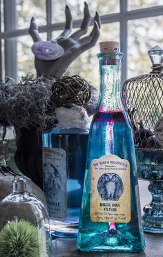 a bottle of alcohol sitting on top of a table next to other bottles and vases