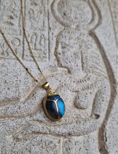 This amazing pendant will make you feel like a living goddess Hand-carved scarab, an ancient reproduction, inlaid with a genuine deep blue shimmering labradorite stone. The gem fits perfectly in the gaps of the beetle. A beautiful tribute to ancient Egypt and to the divine archetypes that we incarnate. In ancient Egypt, the fascinating Scarab Beetle was associated with the solar cycle, as a concept of rebirth and regeneration. The God Khepri was rising the sun every day before rolling it above the horizon, then carried it through the other world after sunset, just to renew it, again, the next morning. The decisive symbolism came from the association of the dung ball to the sun: the scarab rolling his dung ball provided an explanation of the sun's movement in the sky. Powerful amulet used a Artisan Ankh Jewelry For Gift, Beetle Jewelry, Scarab Jewelry, Egyptian Scarab, Scarab Beetle, Egyptian Revival, Unusual Jewelry, Blue Necklace, Gems Jewelry