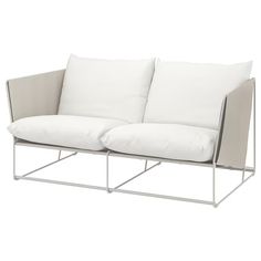 a white couch with two pillows on it's back and one pillow in the middle