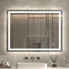 a bathroom with a sink, mirror and lights on the wall above it's counter